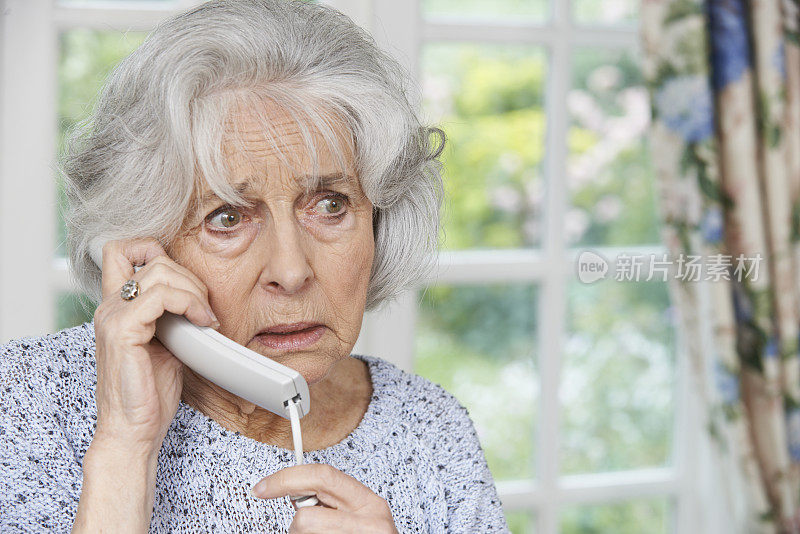 忧心忡忡的老妇人在家接电话