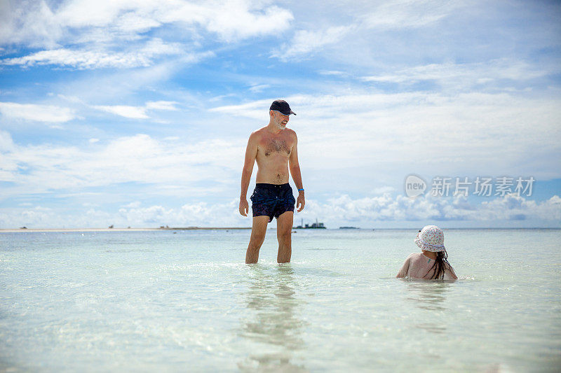 热带海滩上顽皮的父亲和女儿