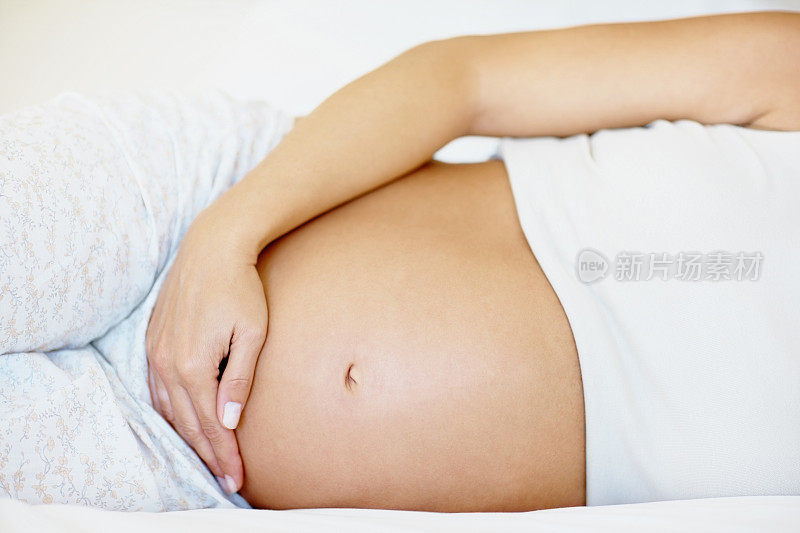 孕妇躺在床上的腹部