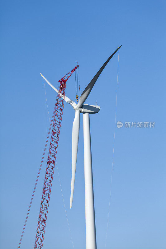 风力发电机正在建设中，红色起重机定位转子