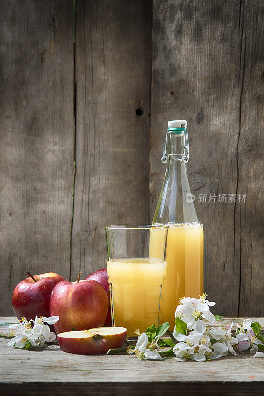 自制的新鲜苹果汁，装在玻璃杯和瓶子里，配上苹果