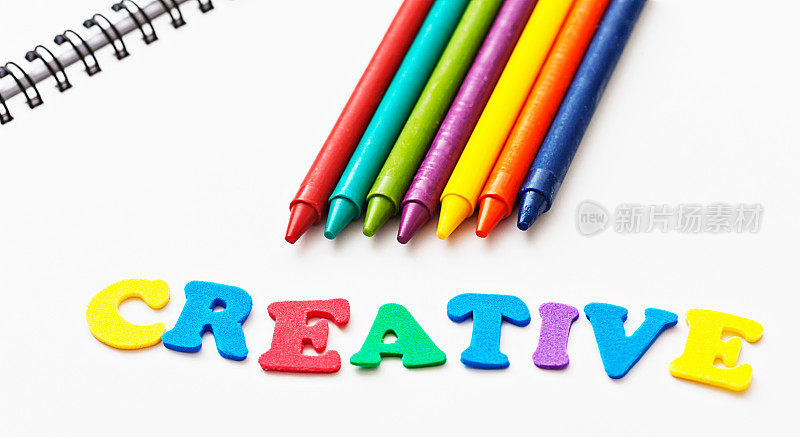 用彩色蜡笔在速写本上拼出“创意”的玩具字母