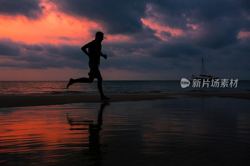 一个男人在海滩上跑步的剪影