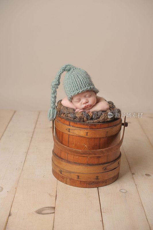 早产儿戴着帽子在复古桶里安静地睡觉