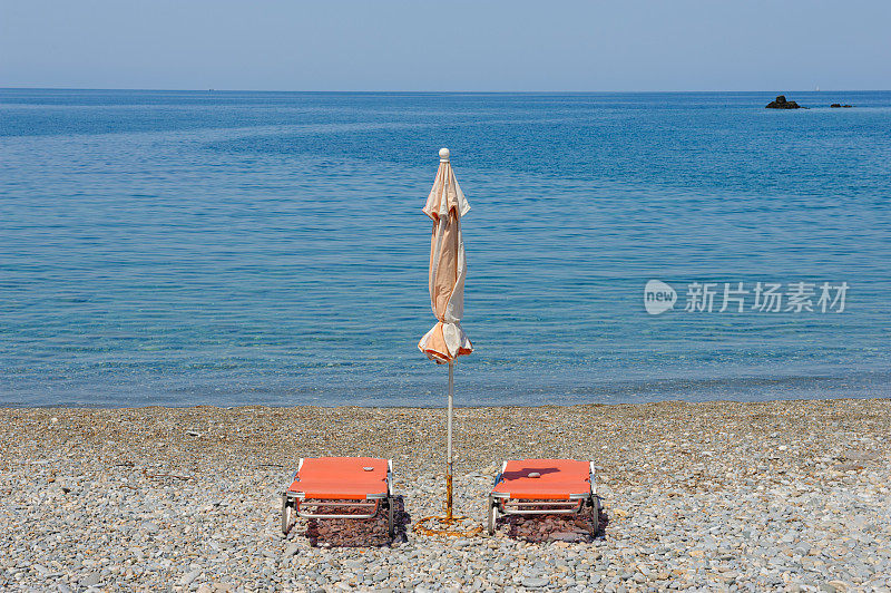 两个日光浴床和雨伞在Tsoukalia海滩，阿隆索斯