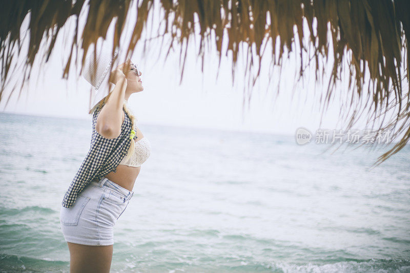 穿着夏装的女人望着天空和大海