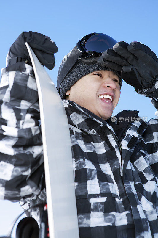 快乐的男性滑雪板对蓝色的天空