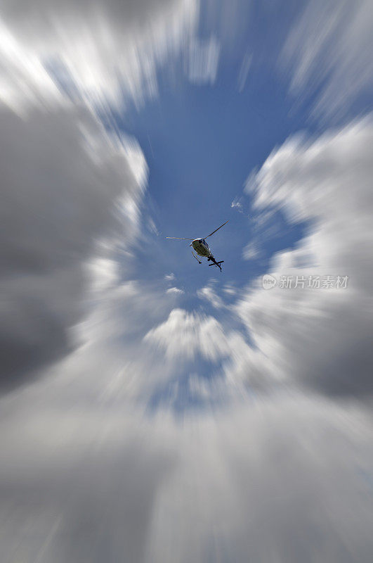 透过云层，一架直升飞机和蔚蓝的天空——变焦应用