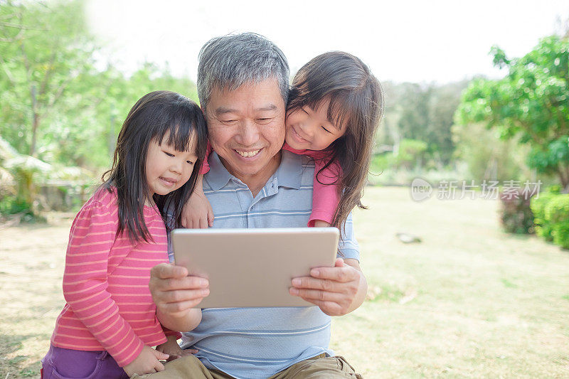 爷爷和孙女们看着平板电脑