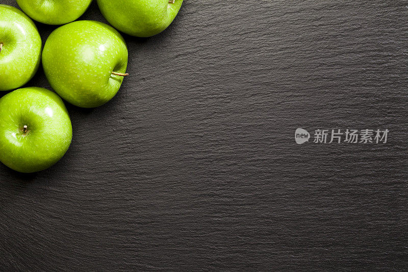 绿色的苹果在黑色的石板背景拍摄直接上方