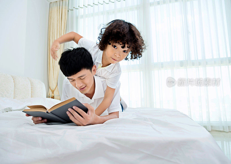 父亲和儿子在床上看书
