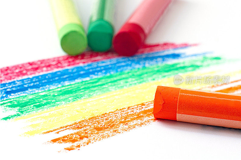 彩虹色图案和橙色油蜡笔在白色的背景