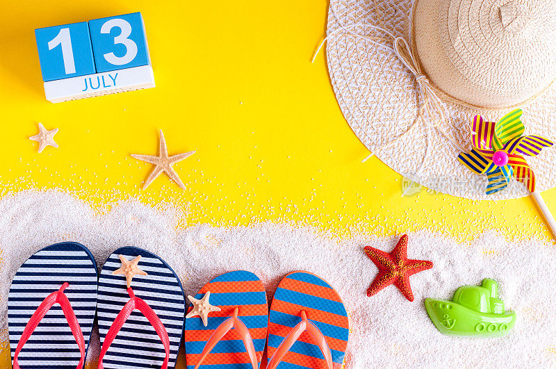 7月13日。7月13日的日历图片，以夏日海滩饰品和旅行者服装为背景。夏日，度假概念