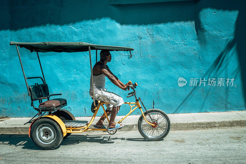 自行车出租车司机和他的车辆，古巴