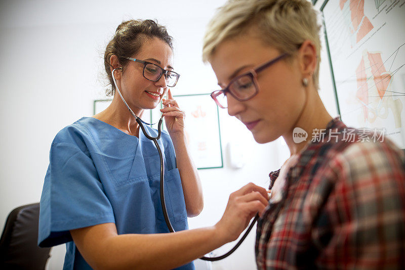 可爱的中年专业护士在门诊医院为担心的短发病人检查健康状况。