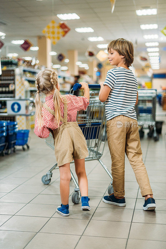 在超市里推着购物车的孩子们