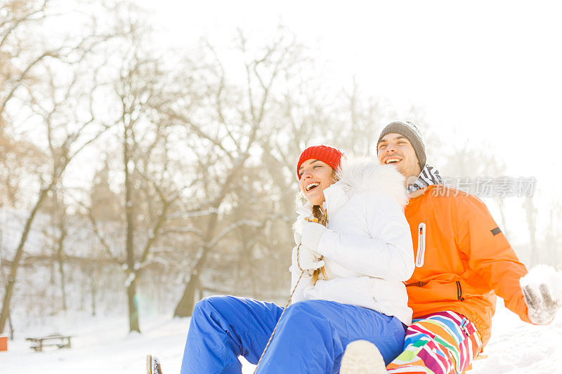 一对夫妇在雪地里拉雪橇