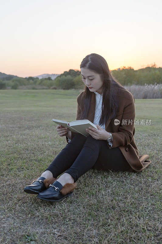 漂亮女人在草坪上看书