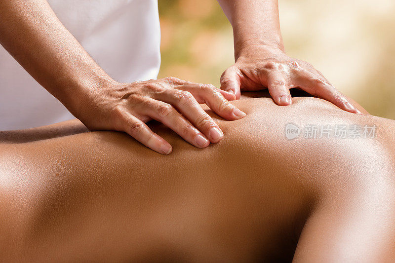 治疗师的手放在女性背部的细节。