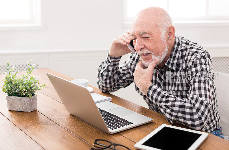 一个老男人用笔记本电脑打电话
