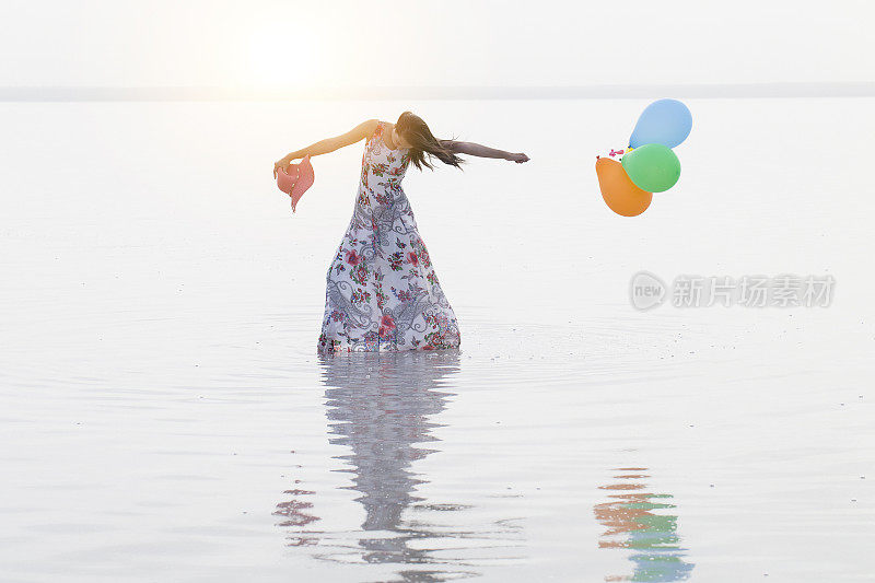 动机或希望的概念，追随你的梦想和灵感，女孩与气球在日落