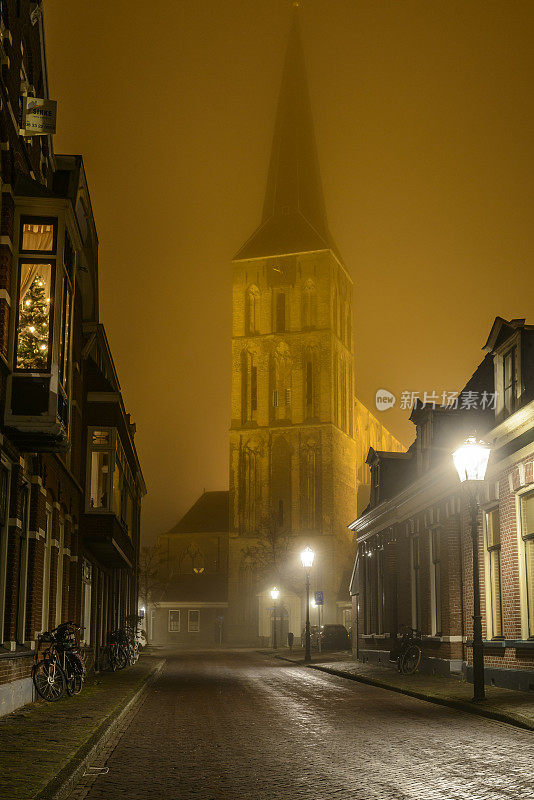 在一个雾蒙蒙的冬天夜晚，在Kampen的Bovenkerk教堂的夜间街景