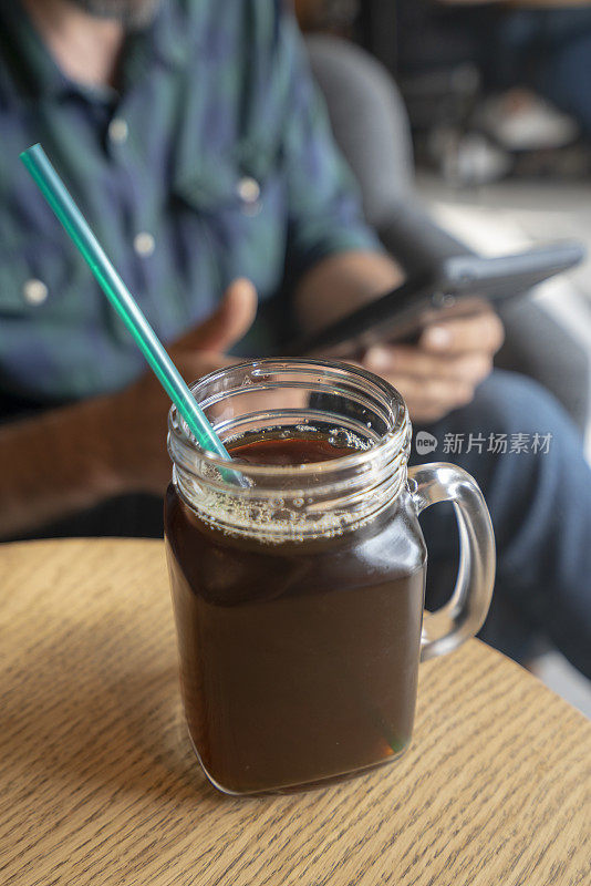 一个年轻人在咖啡店里冰咖啡杯的照片