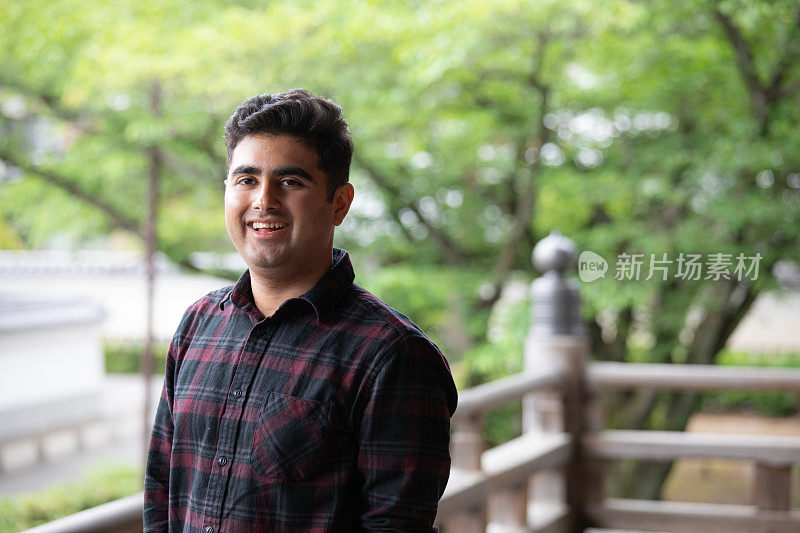 一名亚洲男子走在寺庙阳台上