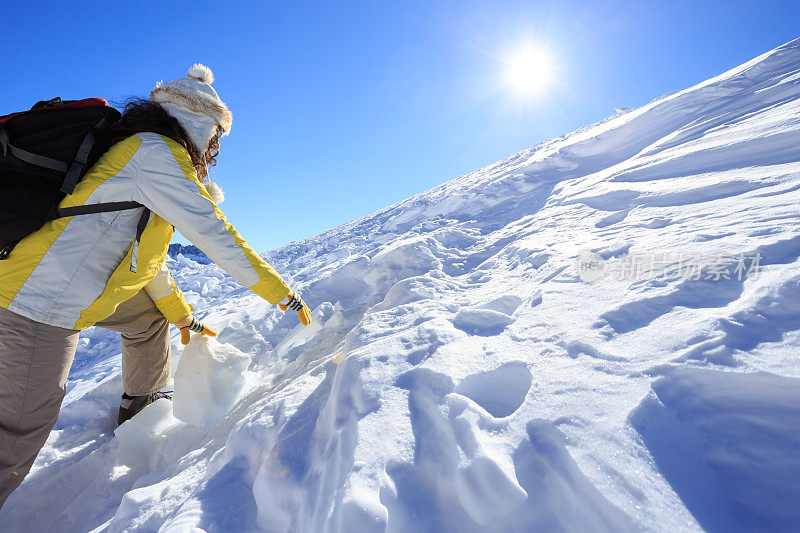 女背包客爬上雪山