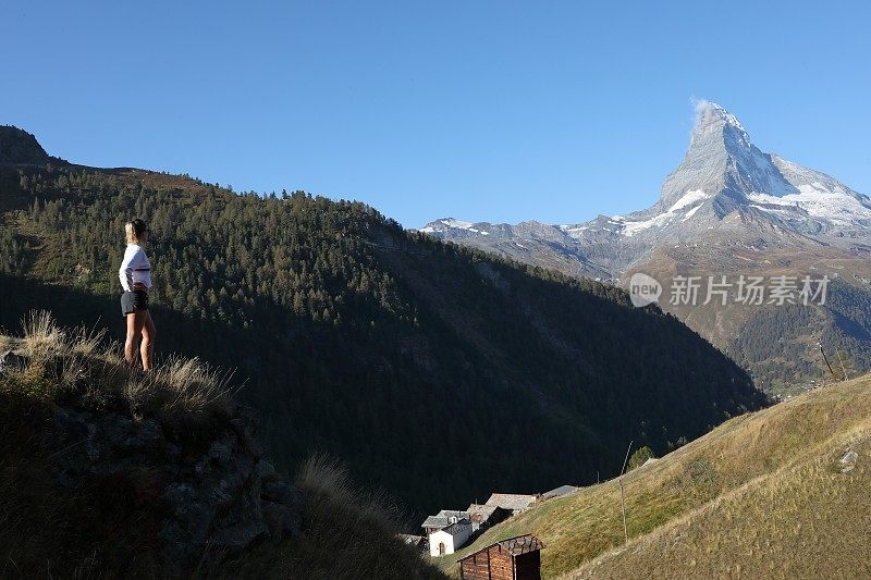 年轻女子一边伸懒腰一边看风景