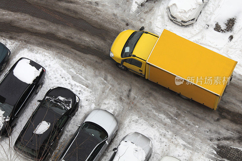 俯瞰结冰的城市街道上黄色的货车