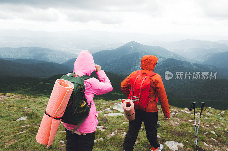 一对年轻的背包客在山里徒步旅行