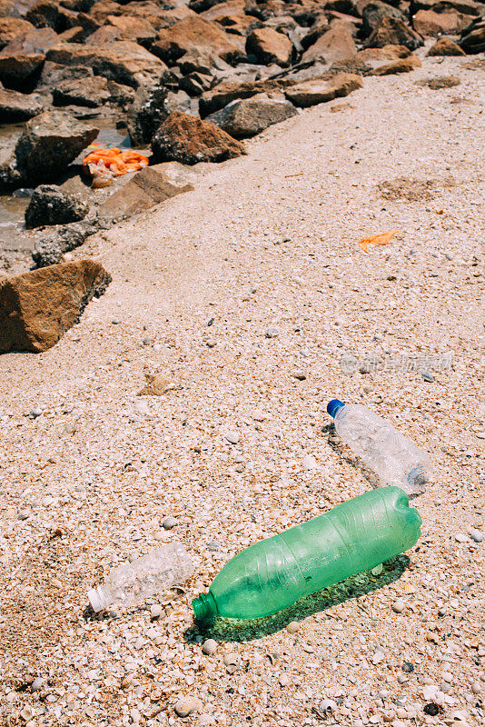 海滩上的垃圾和塑料瓶-海洋环境污染的概念