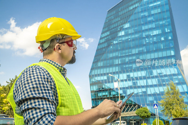 建筑师或建筑工程师在前面的玻璃建筑中使用平板