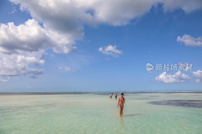 一个年轻的女人在桑给巴尔的一个度假胜地的海滩上。