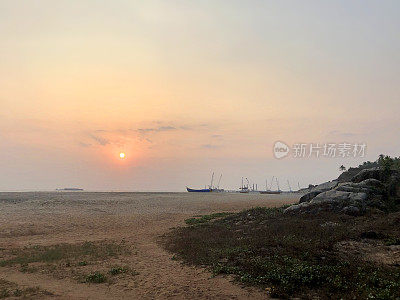 mage的热带海滨海岸和海岸线棕榈树的剪影，日落在果阿海滩海边在冬季日落，Palolem，南果阿，印度，度假，橙色的日落倒影照片，拍海浪的背景