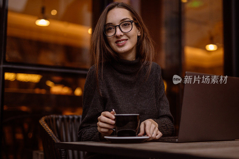坐在咖啡厅休息的女人正在用笔记本电脑