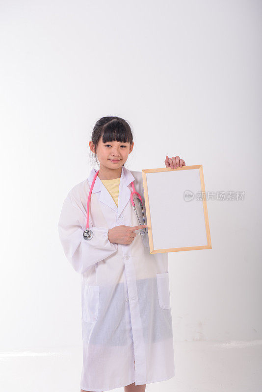 年轻的亚洲医生拿着听诊器举着告示板