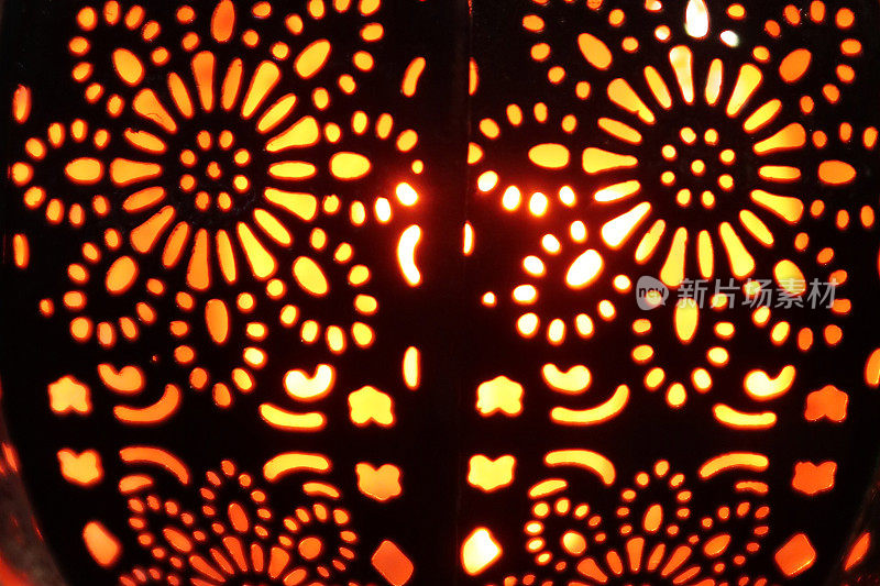特写图像的照明金属灯笼，华丽的切口图案，发光的摩洛哥风格灯笼室内照明