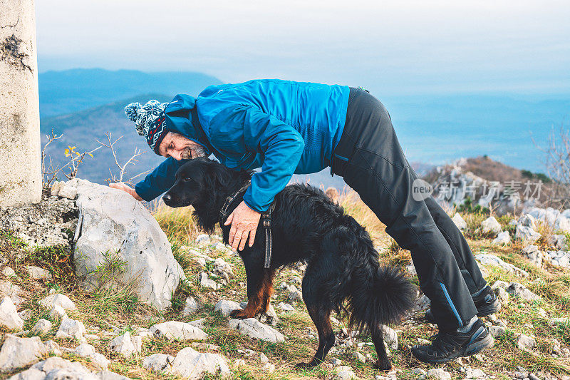 老人和黑狗在意大利南阿尔卑斯山徒步旅行