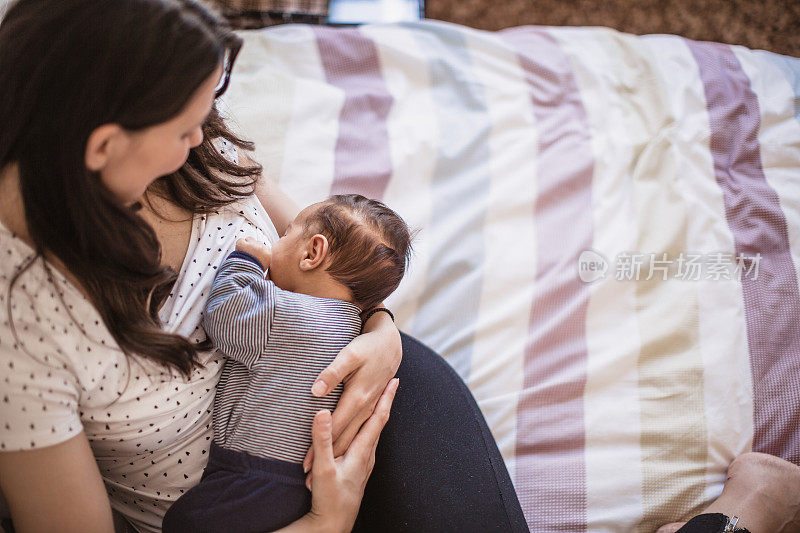 年轻的母亲正在母乳喂养她的男婴