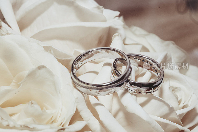 奶油色玫瑰花束上的结婚戒指