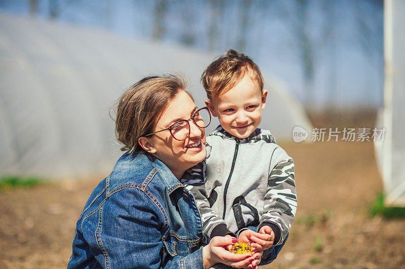 母子在大自然中采摘花草。