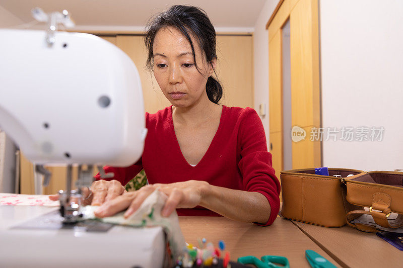 一名日本妇女在家里制作面具