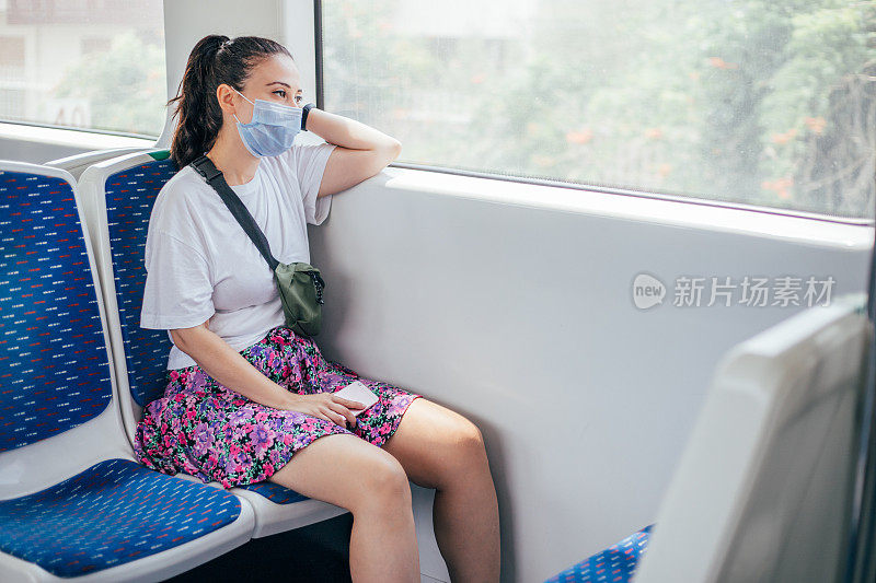乘坐火车时戴着消毒口罩的妇女