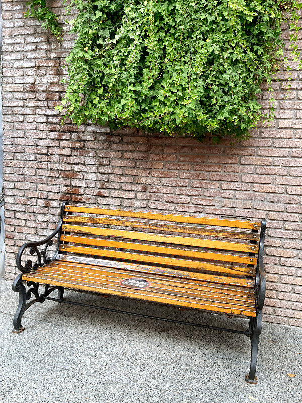 砖墙旁人行道上的长凳