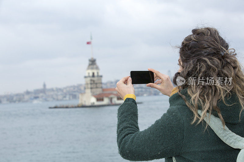 年轻女性游客在土耳其伊斯坦布尔用智能手机拍照