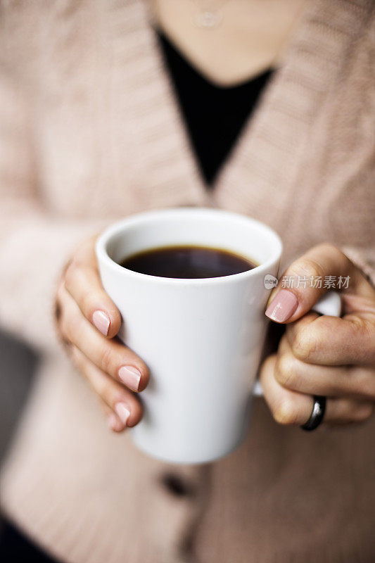 咖啡杯，女士的手拿着咖啡杯，女士拿着一个白色的杯子