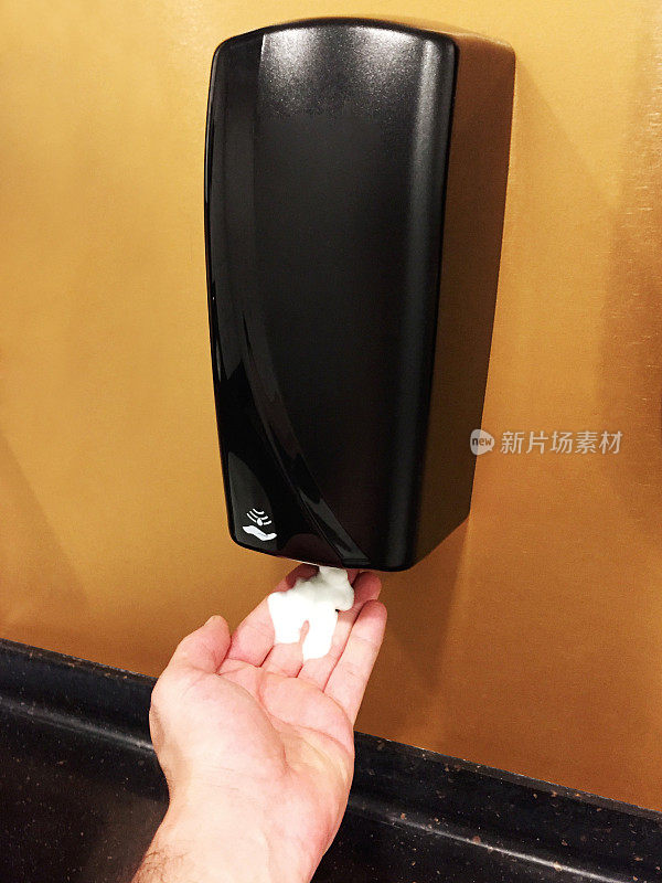 一个使用自动皂液器的手