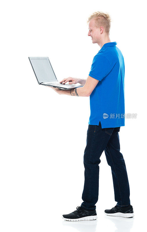 白人男性穿着polo衫站在白色背景前使用电脑